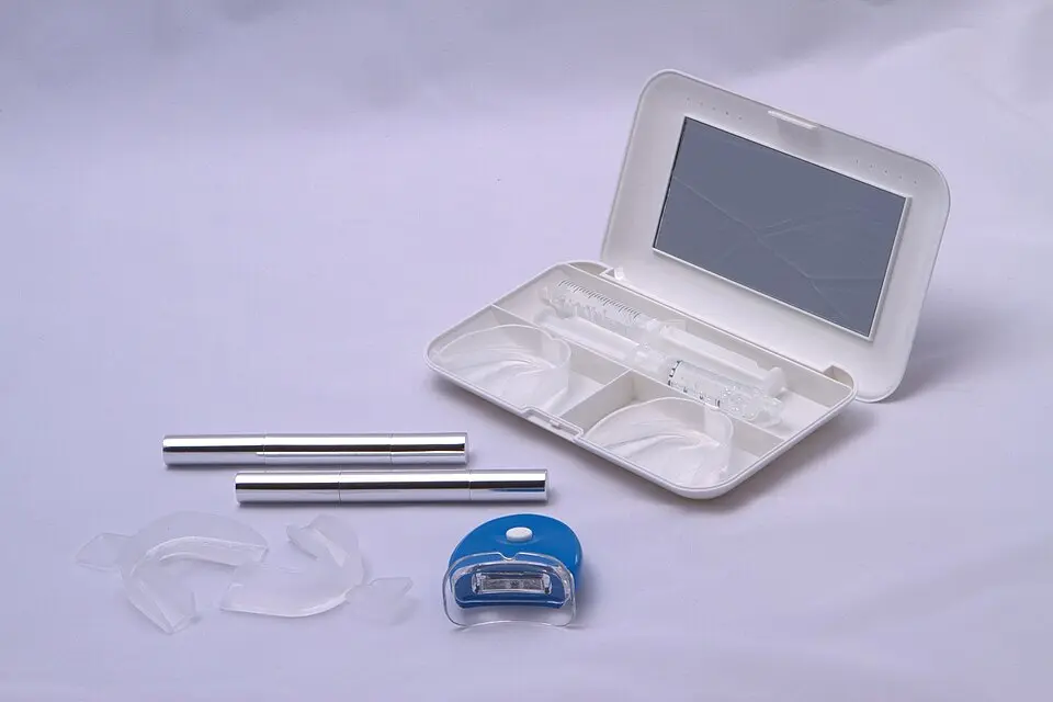 اجزای رایج کیت سفیدکننده خانگی؛ ناودانهای شفاف، ظرفهای ژل، دو قلم و چراغ کوچک آبی